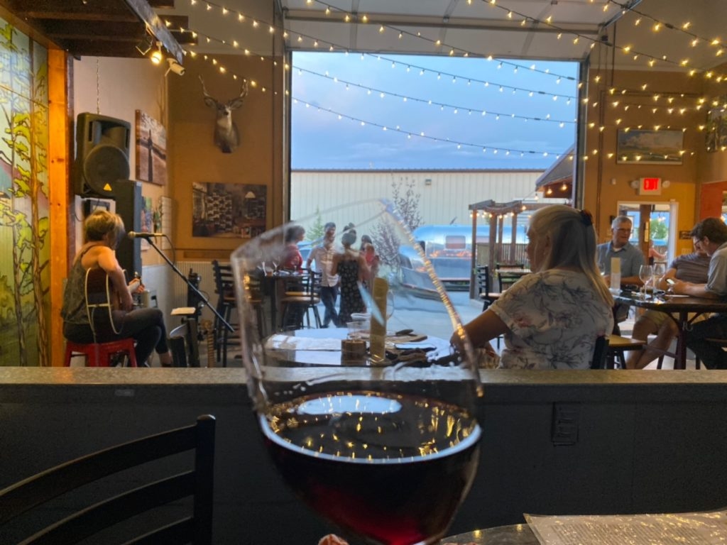 A happy customer enjoys their wine indoors.
