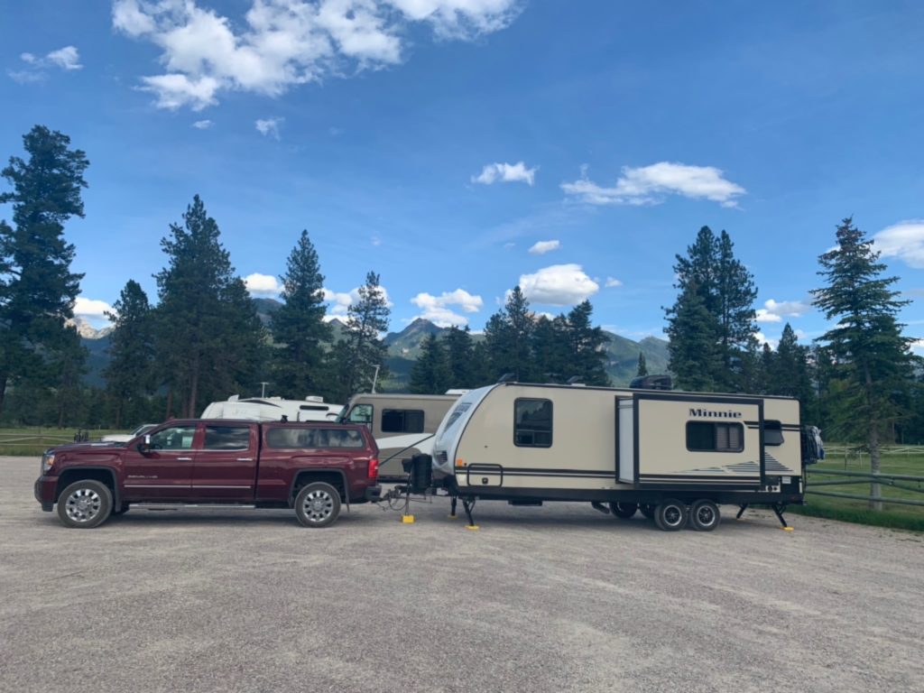 A truck and travel trailer sit parked on the blacktop at Silver Knot.