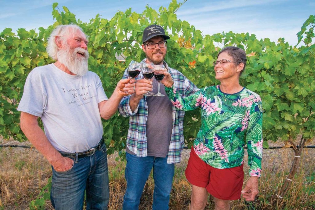 Marilyn and Bob cheers drinks with their son Josh in their vineyard at Tongue River Winery.