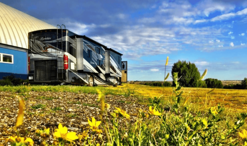 An RV sits beside a barn on a farm